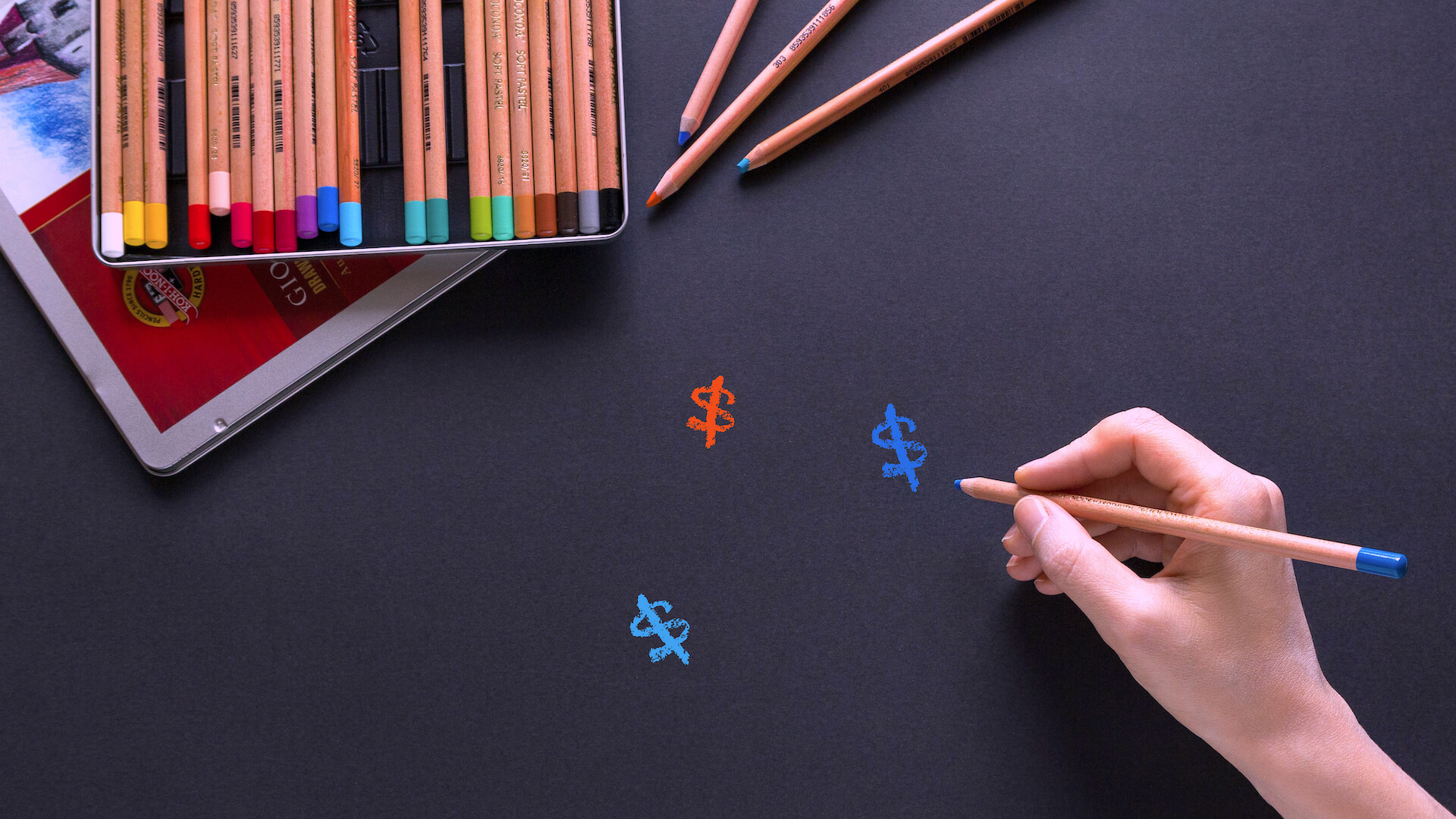 Women hand drawing dollar signs with color pencils